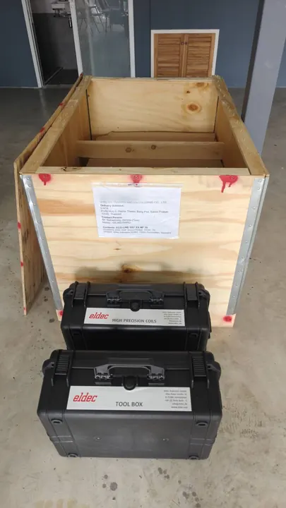 ลังไม้ที่ส่งจาก eldec Germany มีฉลาก Contents ECO-LINE EEI² XS MF 30 และเคส eldec High Precision Coils กับ Tool Box วางด้านหน้า